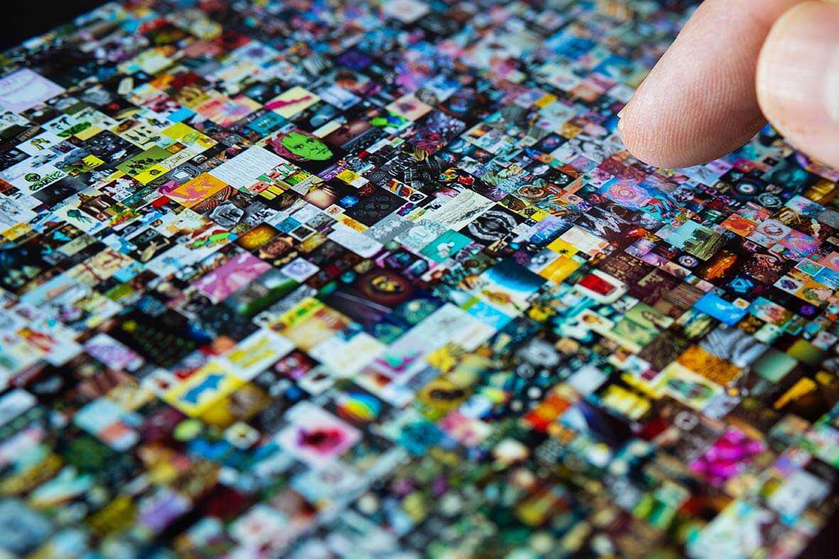 a finger is hovering over an almost unintelligible array of tiny icons and images which have been stored digitally as NFTs