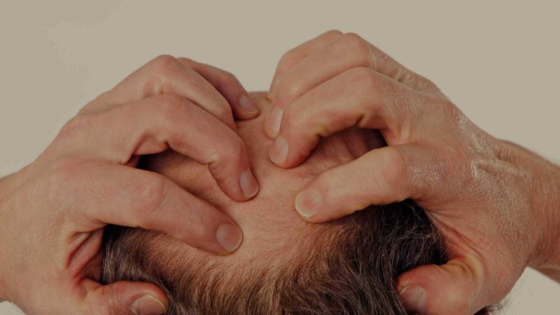 A photo of the back of a man's head, which he's clutching with both hands as it if to suggest anxiety or concern. The photo has been selected to hint at the worries people have right now about moving forwards with the marketing strategy.