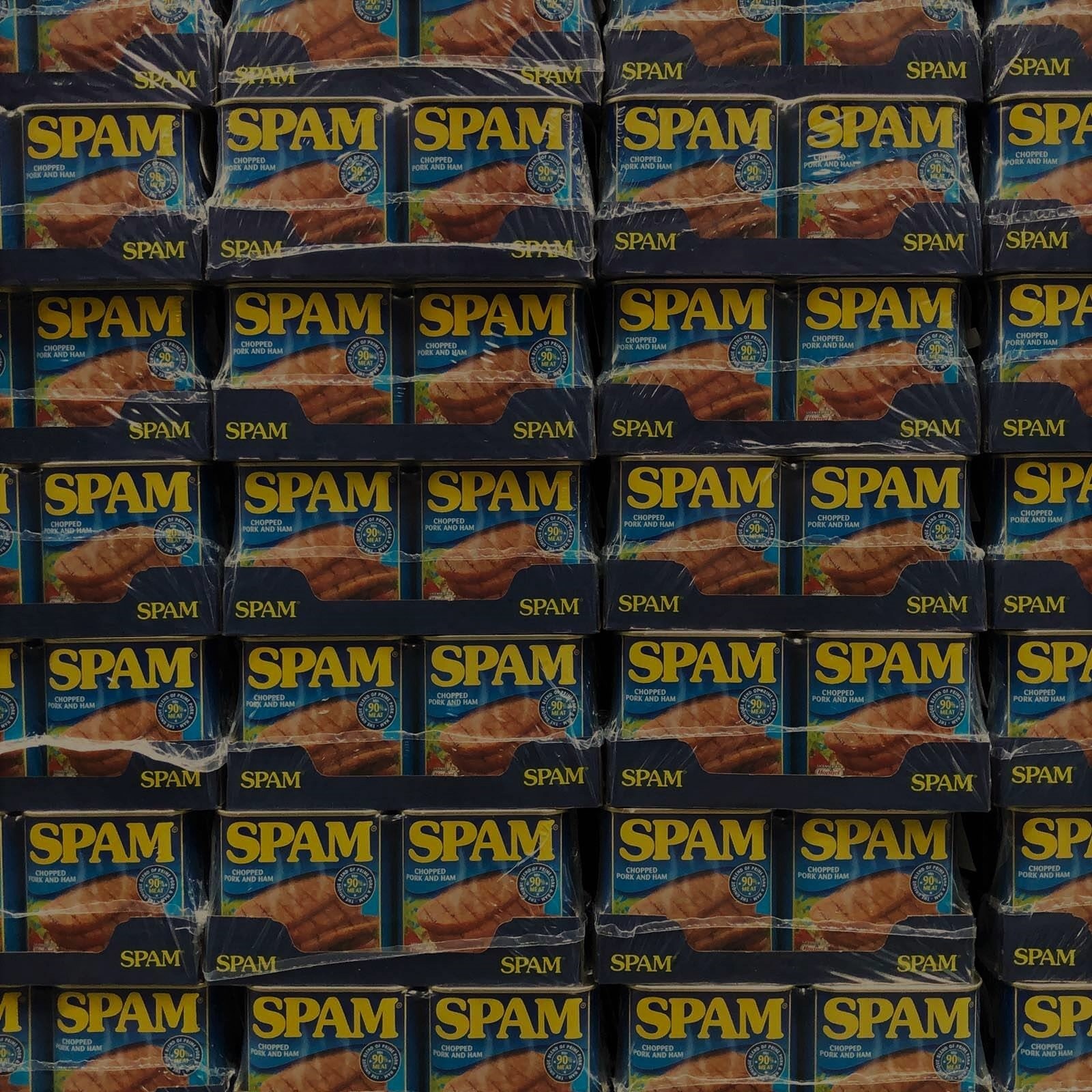 An image of a cases of the tinned food SPAM, piled up so that that is literally all you can see in teh photo. Each tin has the word SPAM written clearly in yellow, on a blue background with an indistinct photo of the heavily processed meet slices. Spam in this image is suggesting that email marketing can sometimes be dealt with as spam, i.e. something unwanted and treated as junk.