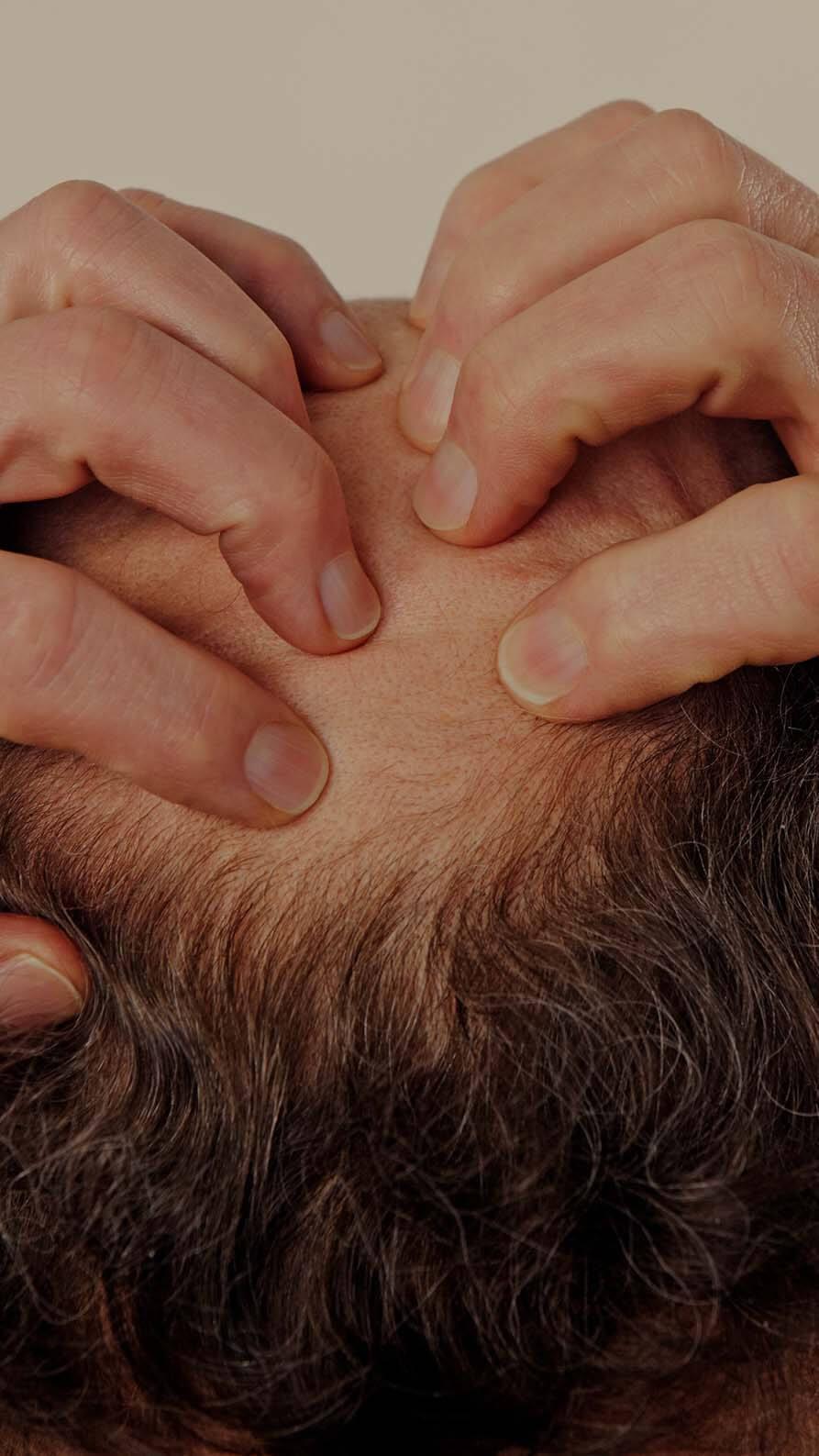 A photo of the back of a man's head, which he's clutching with both hands as it if to suggest anxiety or concern. The photo has been selected to hint at the worries people have right now about moving forwards with the marketing strategy.