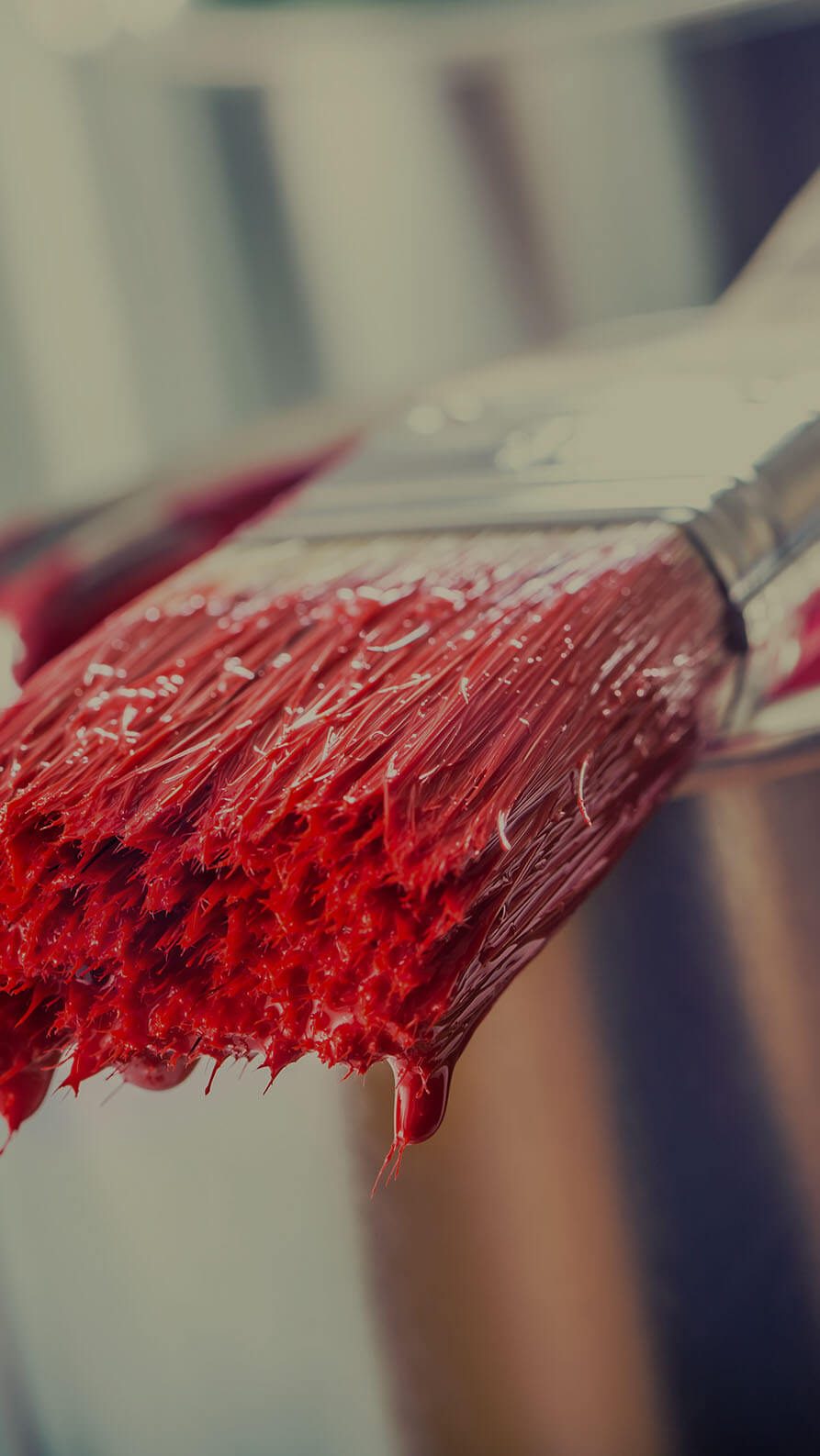 A close up photo of a pain brush which has been dipped in bright red paint and which is resting on the paint pot. This is in reference to article in which the relationship between paint company Dulux and football club Tottenham Hotspur got off to a rocky start.